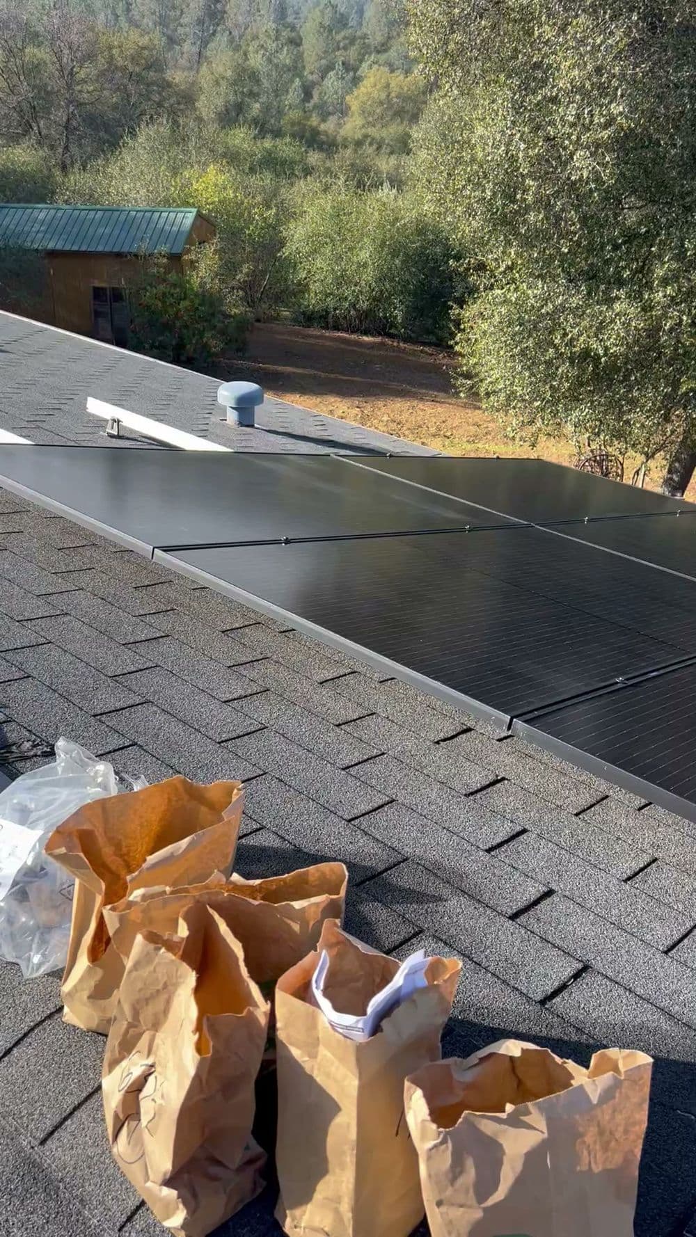 Solar panels installed on a rooftop with brown paper bags nearby for maintenance.