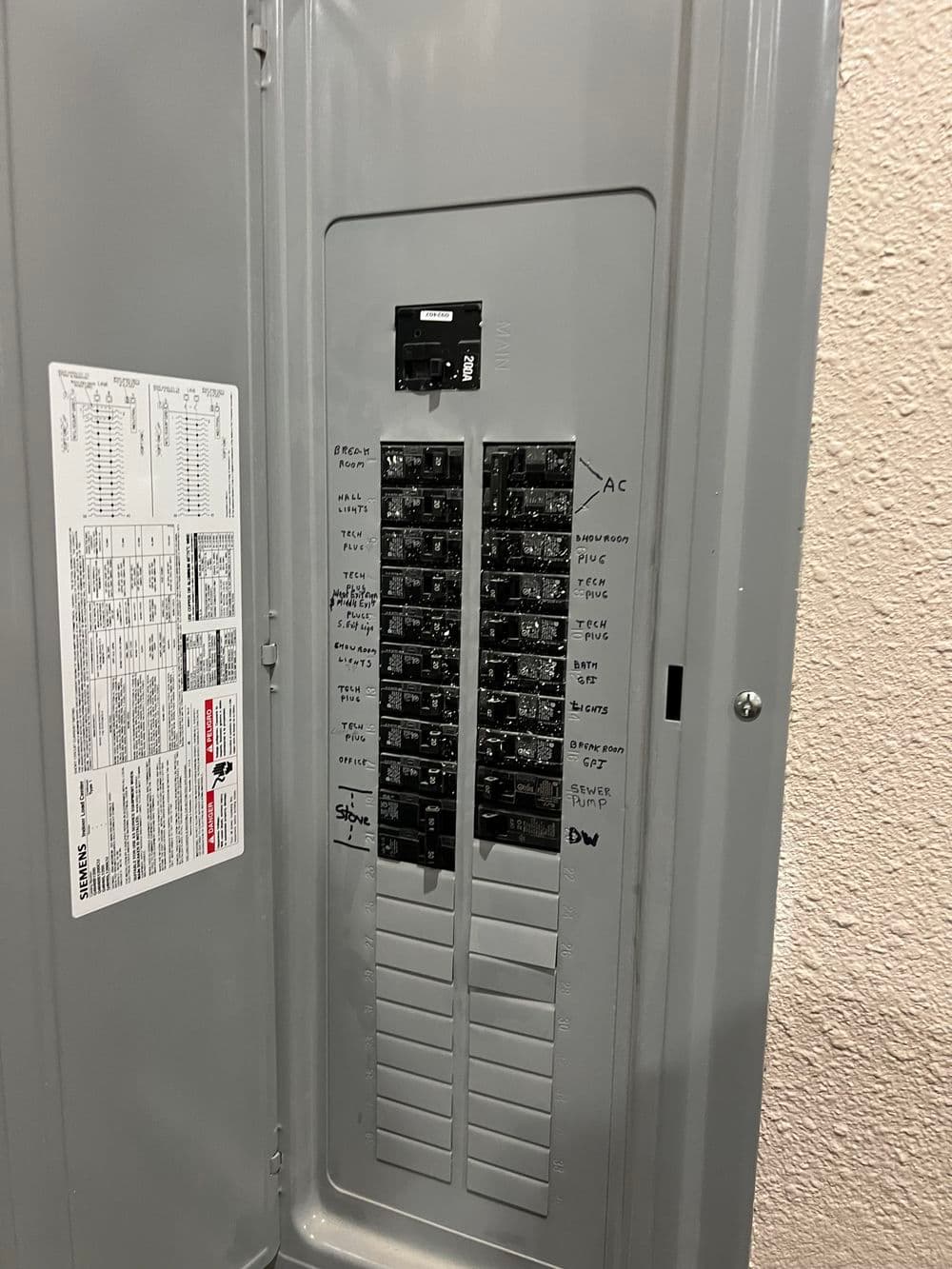 Electrical panel with labeled circuit breakers for home electrical system management.