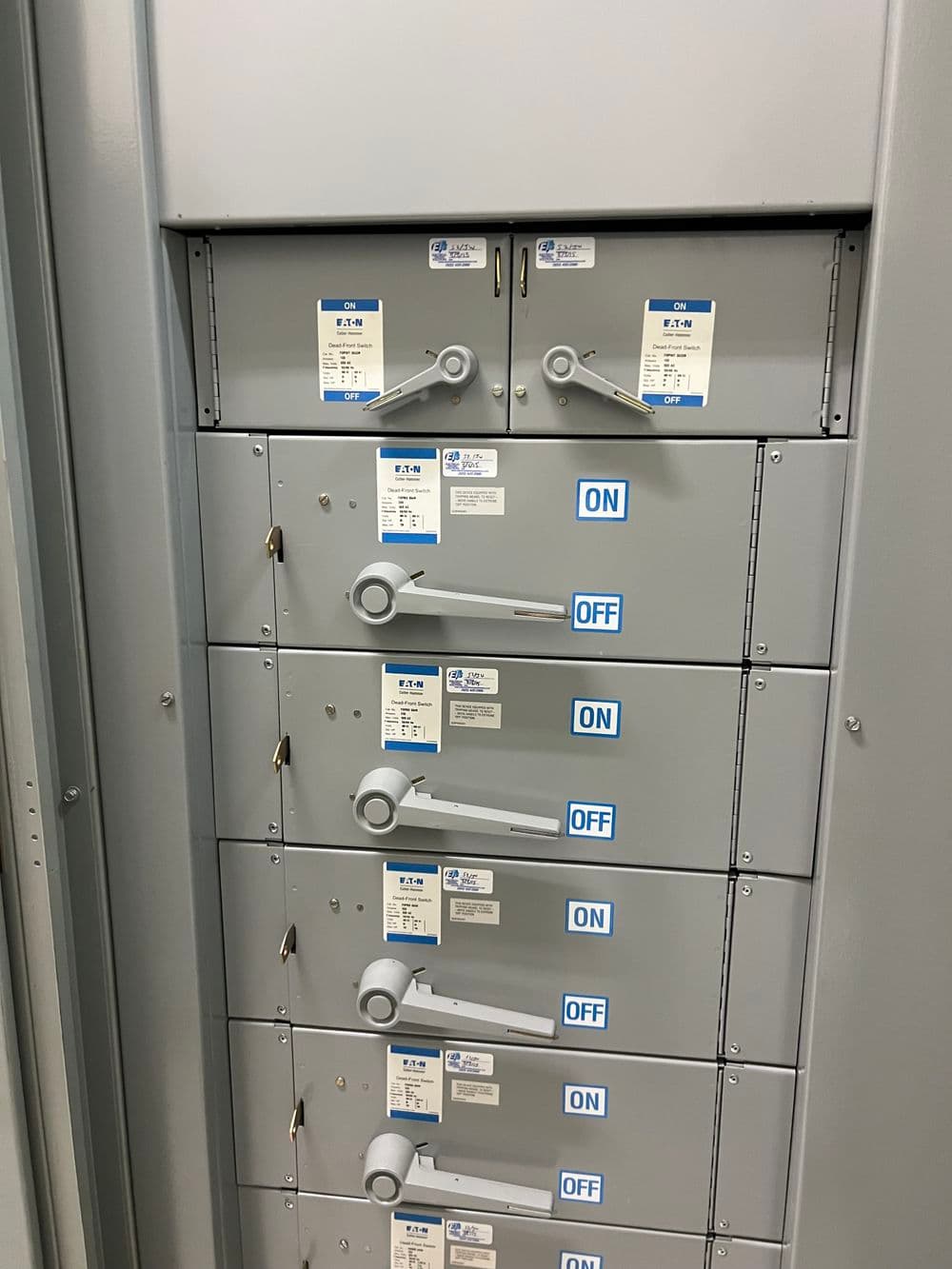 Electrical circuit breaker panel with labeled switches in on and off positions.