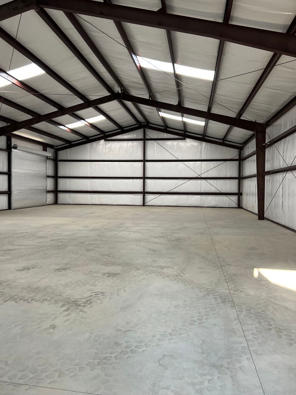 Spacious industrial warehouse interior with high steel beams and natural light.
