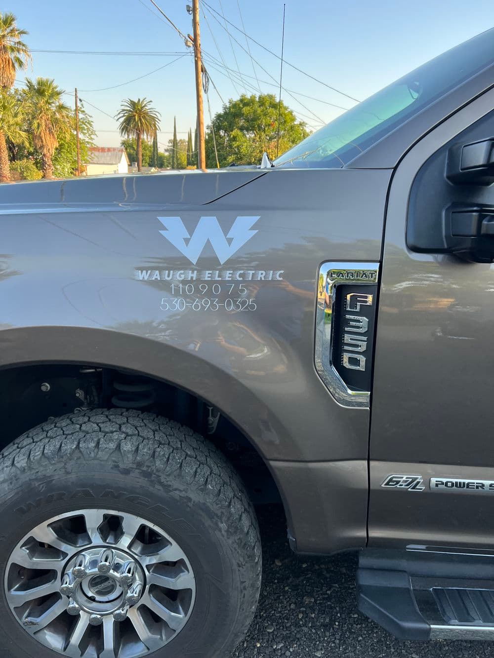 Waugh Electric truck logo with contact details and power equipment branding.